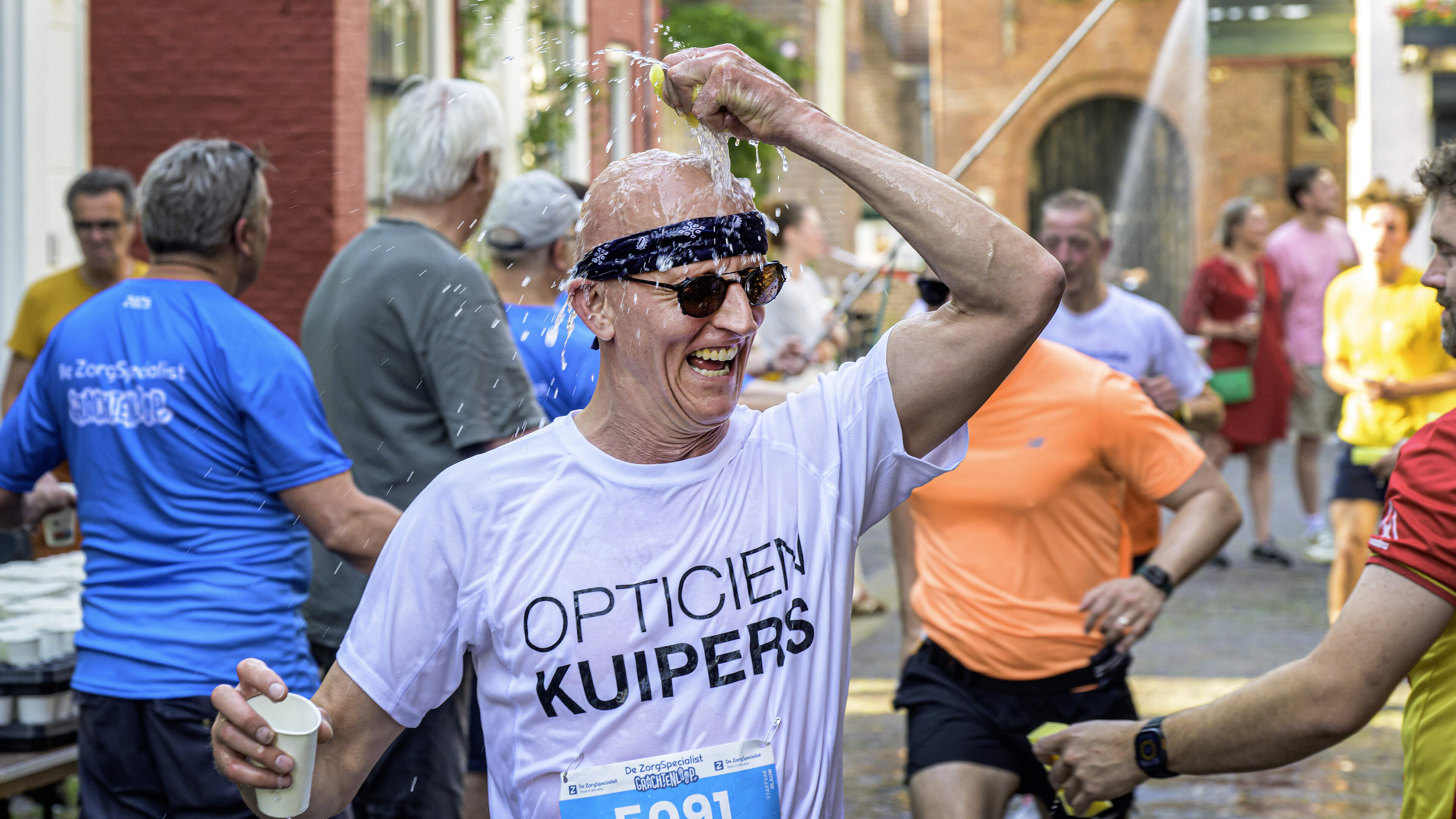 Haarlem residents cool runners with water pistols and hoses during scorching Grachtenloop: ‘Normally I drink wine, now I’m soaking them’